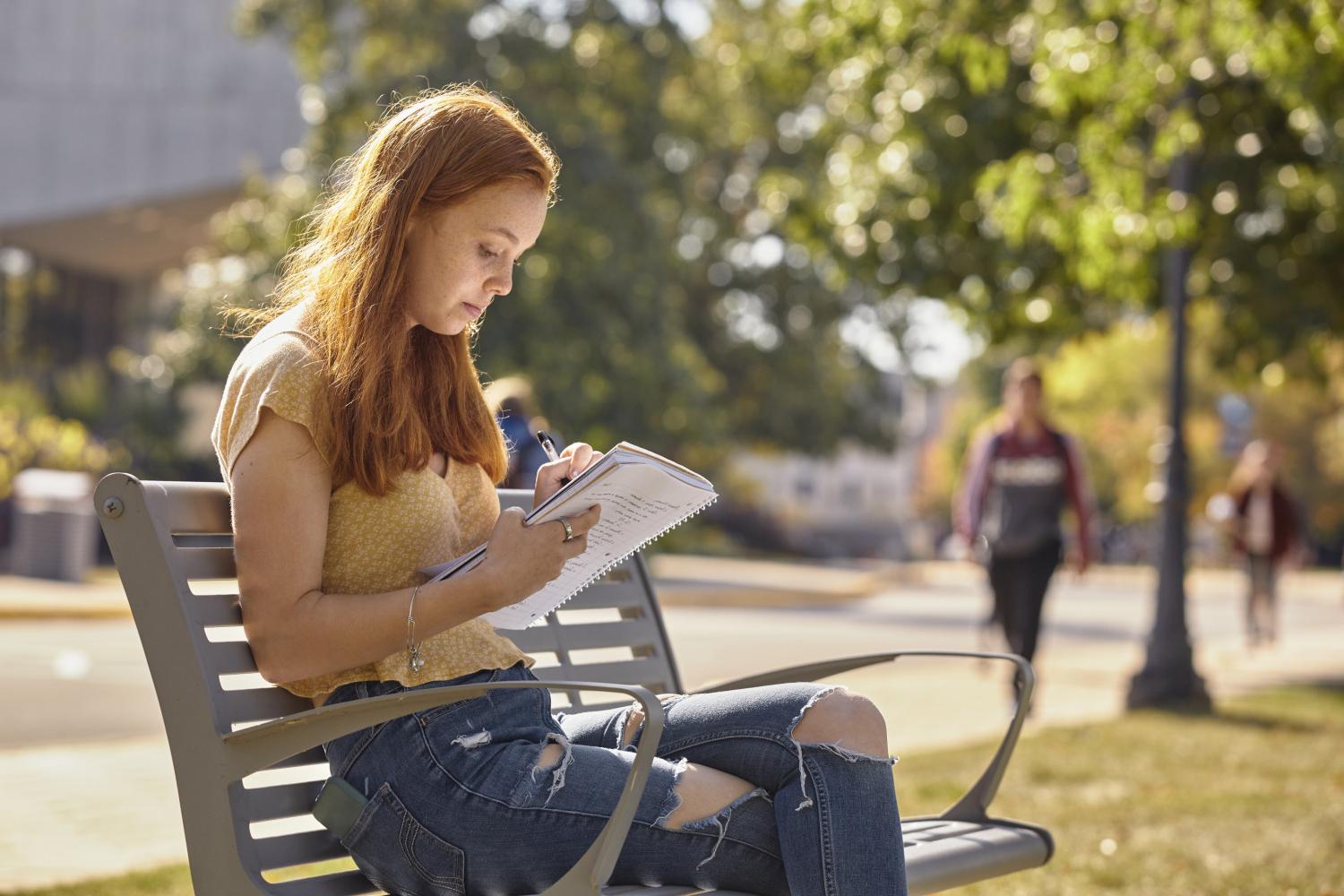 一位<a href='http://fksu.ngskmc-eis.net'>全球十大赌钱排行app</a>学院的学生在校园里的长椅上读书.